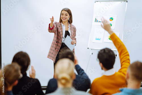 Young woman coach speaker giving flipchart presentation, speaker leading training, mentor leader explain strategy schedule at team meeting. Planning, analysis, collaborate work in teamwork.