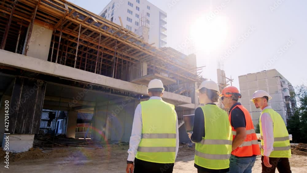 Multiethnic group of diverse specialists at construction site walking to the construction building to analyzing the plan of work