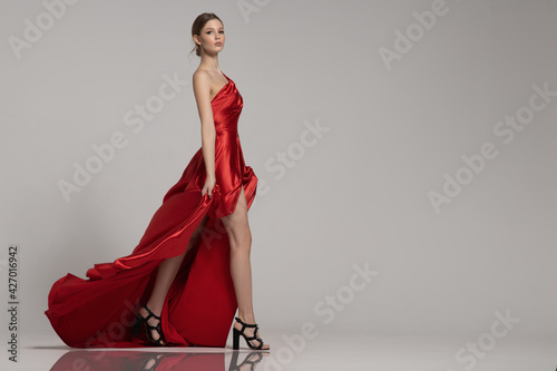 Fotografia fashion woman strides in long red dress