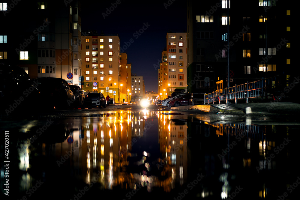 Night life, modern buildings of the capital with the reflection of light in puddles.