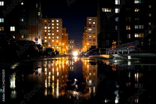 Night life, modern buildings of the capital with the reflection of light in puddles.