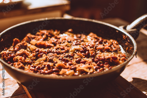 Food ingridients: meat, onion, ginger for recipe stewed beans with meat frying in a pen on a stove. Steps in cooking, process of preparing food. Concept of homemade healthy food.