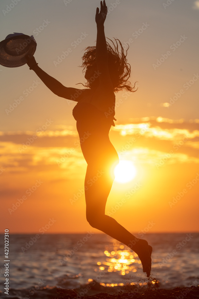 Silhouette of a girl jumping by the sea