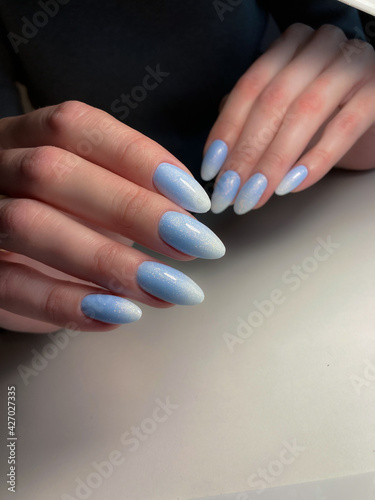 The work of a manicure master. Hands of a beautiful young woman and modern design.