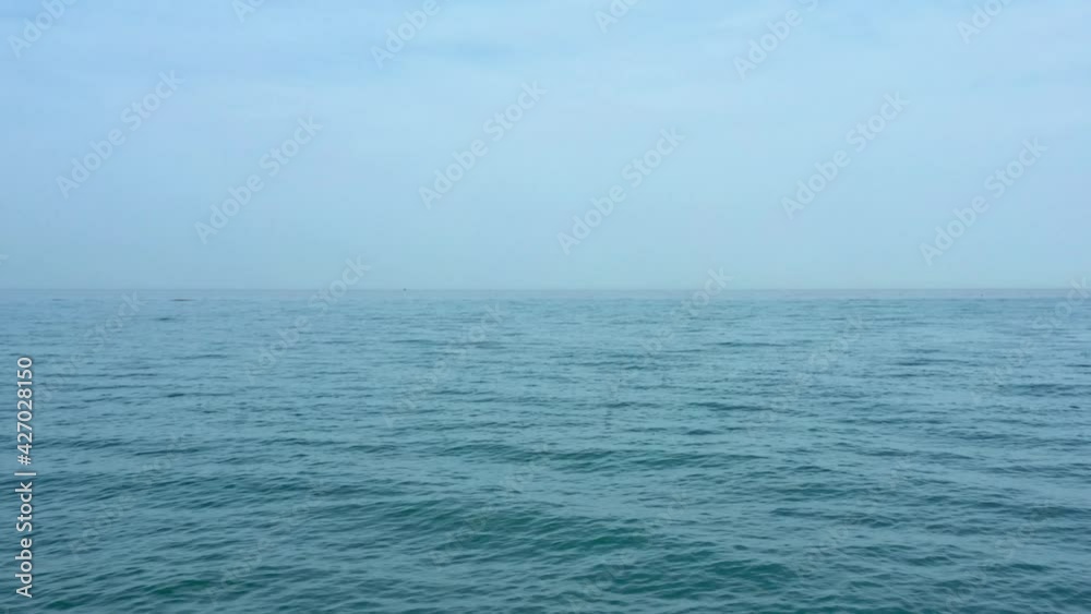 Flying above the dark blue sea toward the horizon, under light blue sky. Aerial footage. Flying above the dark blue sea toward the horizon, under light blue sky. Aerial footage.