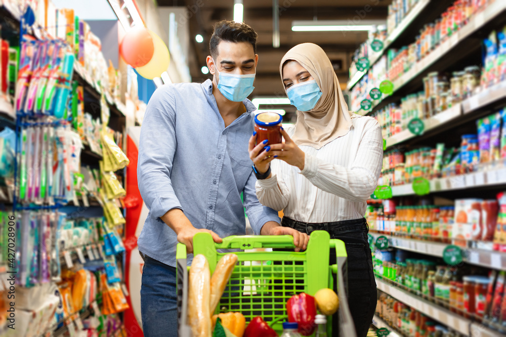Muslim Family Doing Grocery Shopping Buying Food In Supermarket