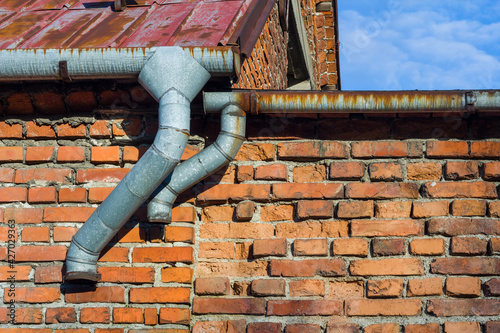 Old factory wall with Weathered Brick Mansonry and Rusty Gutter photo