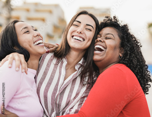Photographie Happy latin women laughing and hugging each other outdoor in the city - Millenni