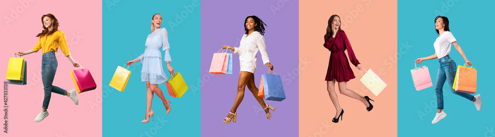 Young diverse ladies walking with bags at colorful studio backgrounds