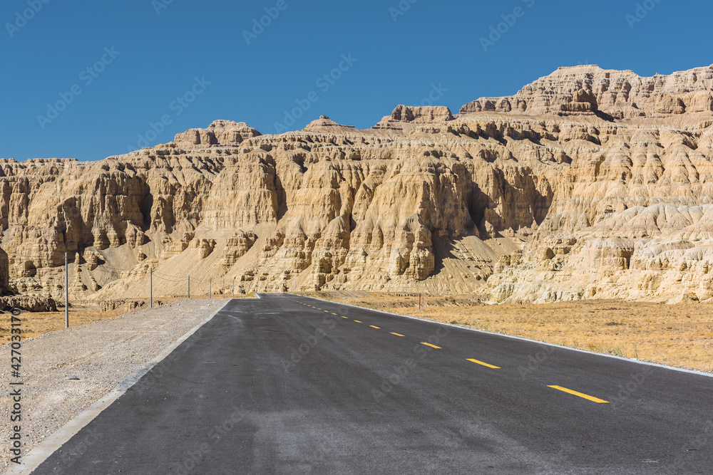 A section of tarmac road in the eroded landscape and rock towers of Zanda soil forest A section of tarmac road in the eroded landscape and rock towers of Zanda soil forest
