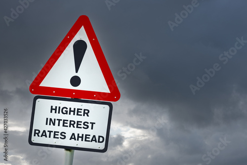 Conceptual European style road sign warning against higher interest rates. Stom clouds in background. Copy space.