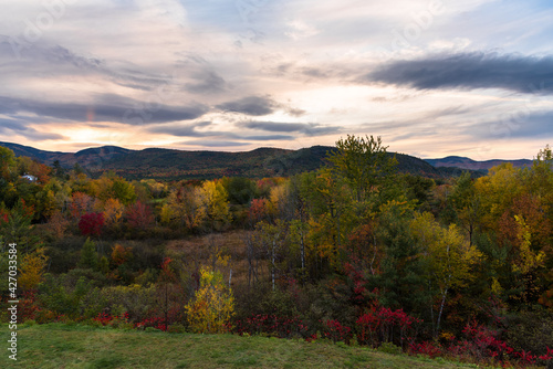 Sunset over a forested mountain landscape during the autumn colour season