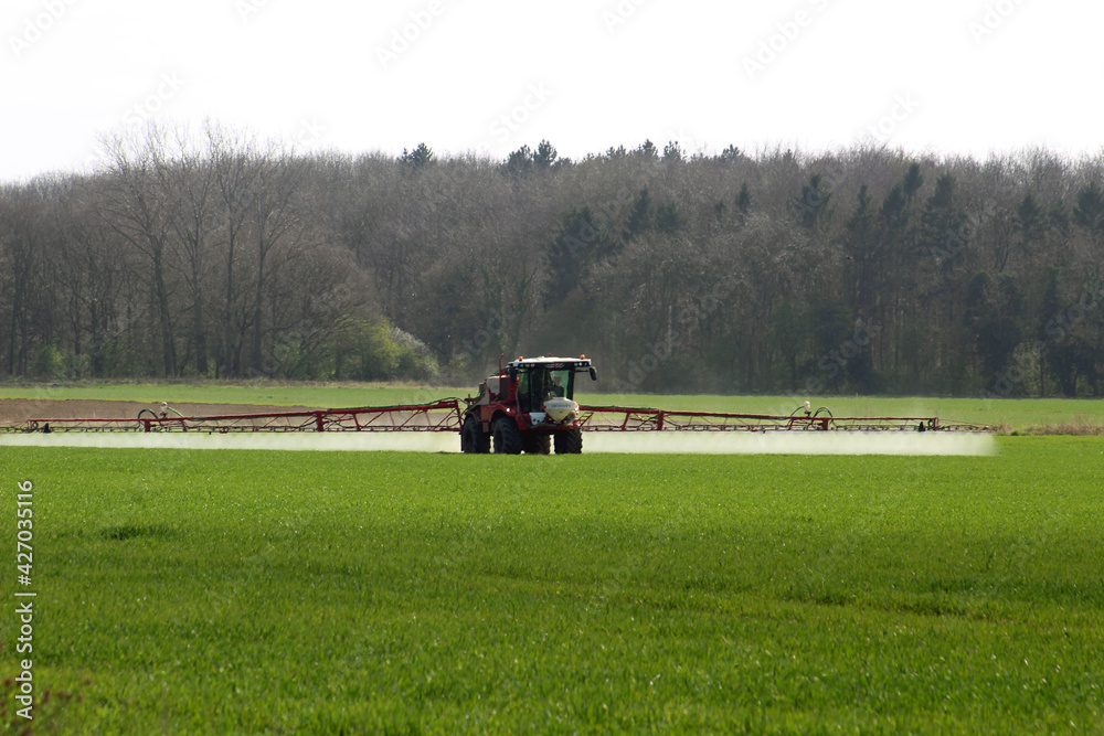 Farmer spraying crops In field in spring time In North Yorkshire April UK