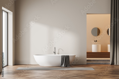 Beige wooden bathroom interior bathtub near window and sink