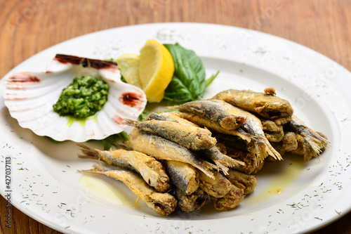 Plate of deep fried anchovies with lemon and salad