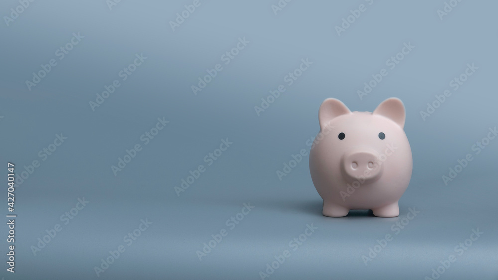 Piggy bank on a grey background with copy space.