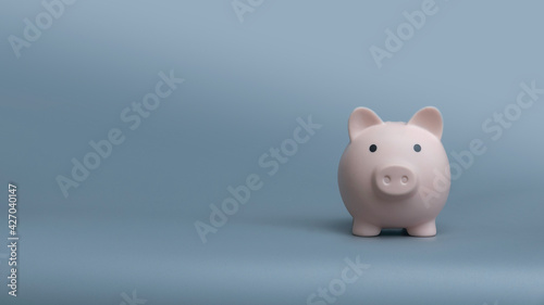 Piggy bank on a grey background with copy space.