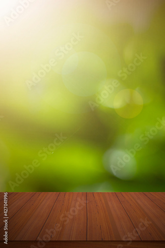 Empty wooden deck table with green spring bokeh background.