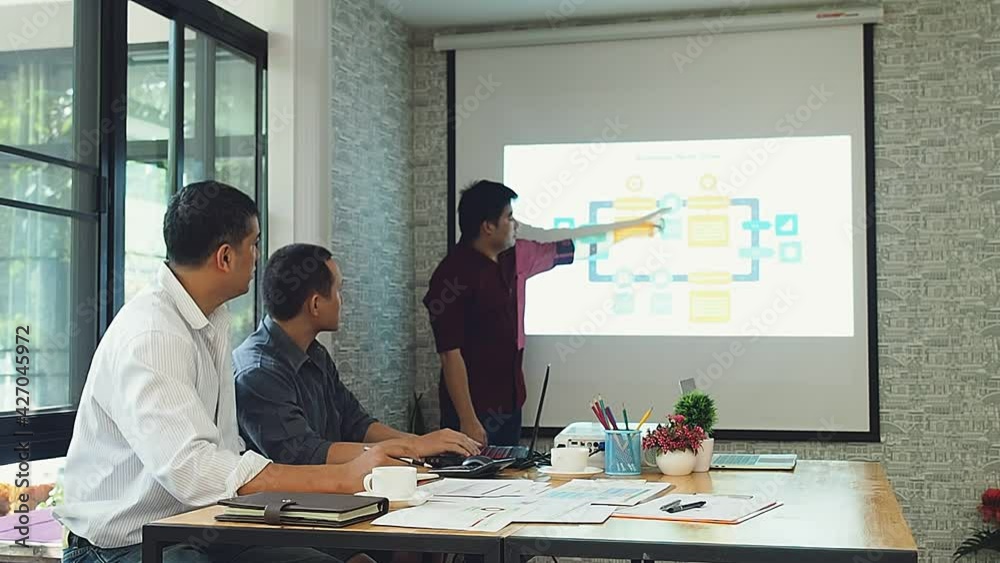 Business people sit and watch colleagues present project in a meeting room. Business team meeting and discussing project plan. Business people sit and watch colleagues present project in a meeting room. Business team meeting and discussing project plan.