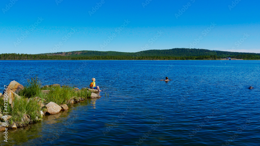 Swimming in a lake in Sweden, during summertime. Enjoying the peace and quiet time. This little connecting lake is located between Uddjaur and Hornavan, near the village Arjeplog in Norrbotten County.