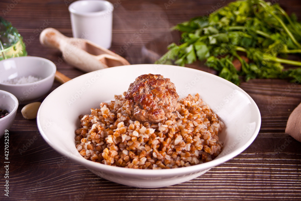 Buckwheat porridge with meat ball on the wooden table. Buckwheat porridge with meat ball on the wooden table.