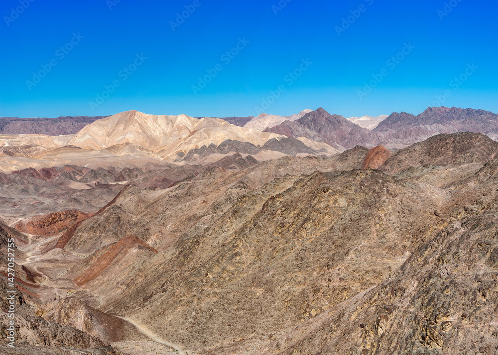 The trail goes through a rocky desert canyon.