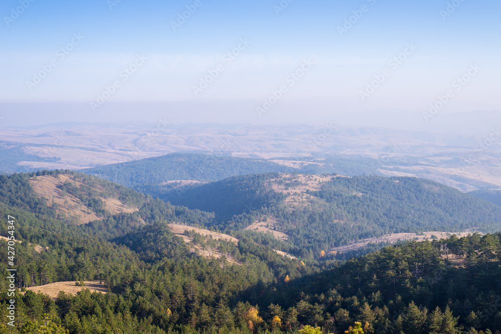 Landscape of hills and valleys on a hazy autumn day