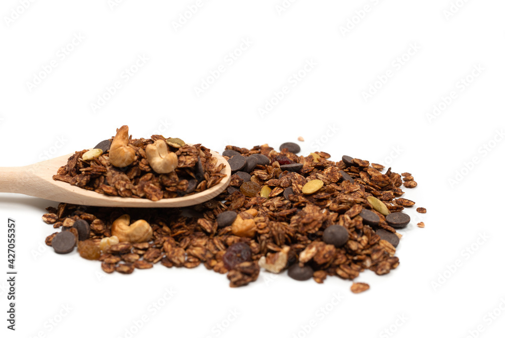 Chocolate granola cereal with nuts in a wooden spoon. Chocolate granola cereal with nuts in a wooden spoon.