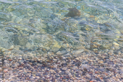 Background of a sea with a crystal clear water and pebbles on the bottom