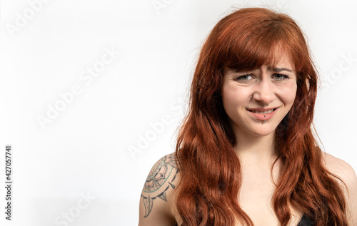 Portrait of girl with red hair infront of white background with disgusted face expression and white space