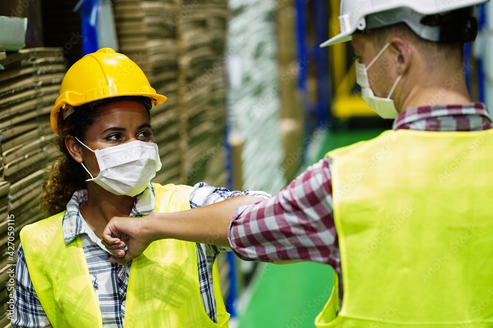 Two workers in factory or supply chain import and export warehouse wear ...