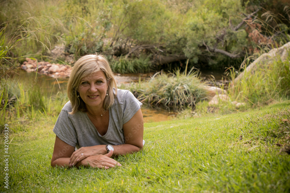 Attractive woman relaxing in nature near stream Attractive woman relaxing in nature near stream