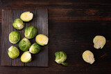 Fresh brussels sprouts on dark wooden background, rustic style, healthy food.