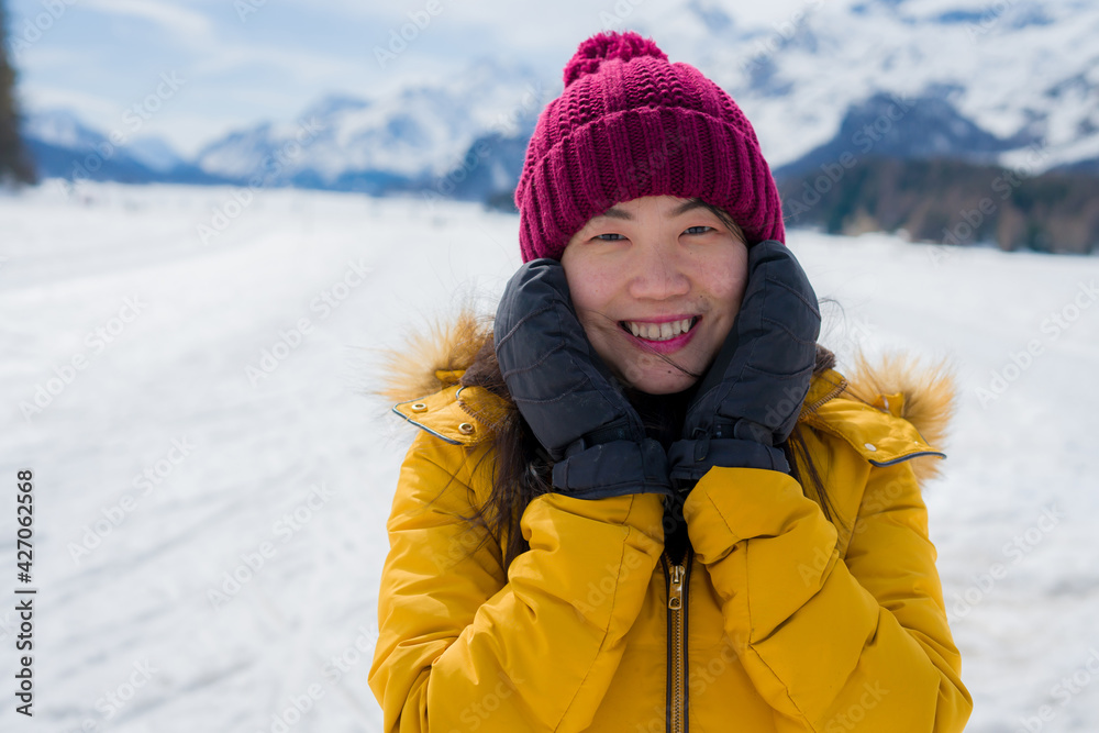 Winter holidays in the snow - lifestyle portrait of young happy and beautiful Asian Korean girl enjoying playful at frozen lake in snowy mountains at Swiss Alps Winter holidays in the snow - lifestyle portrait of young happy and beautiful Asian Korean girl enjoying playful at frozen lake in snowy mountains at Swiss Alps