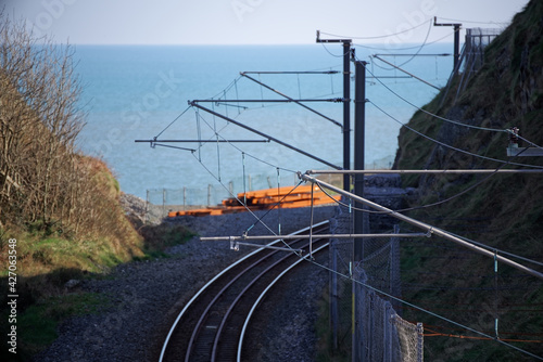 Railroad tracks with blue sea in the background
