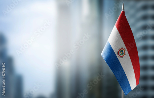 A small flag of Paraguay on the background of a blurred background photo