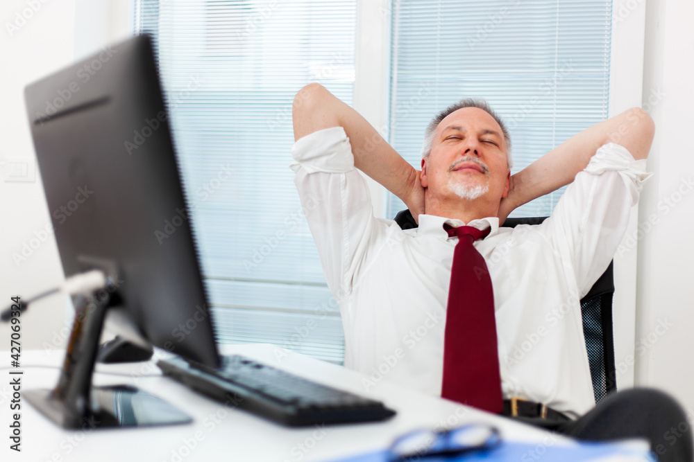 Businessman relaxing in swivel chair in office Businessman relaxing in swivel chair in office