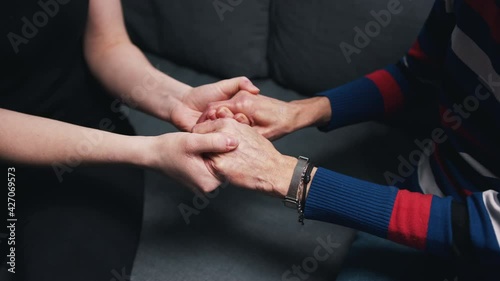 Young person holding hands of an elderly woman. High quality 4k footage