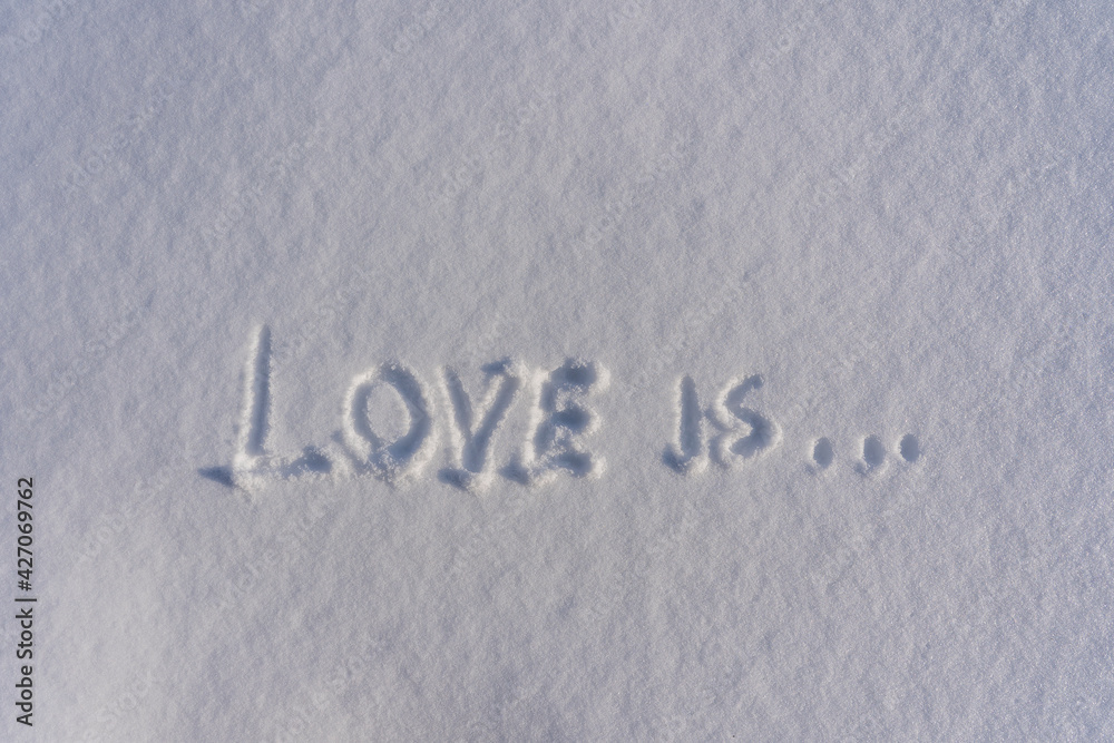 Text love is on a white fresh snow in winter, close up Text love is on a white fresh snow in winter, close up