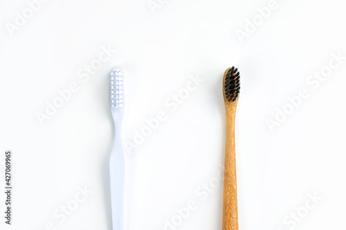 Bamboo toothbrush vs plastic toothbrush concept. Toothbrushes isolated on white background. Save the world. Copy space