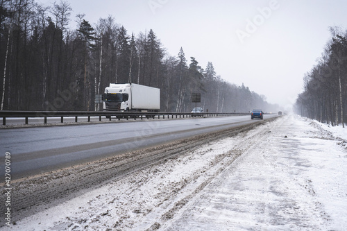 Trucks on the highway in dirty weather, Dangerous driving conditions in winter in cloudy weather.