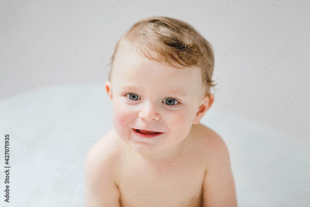 Cute adorable baby child taking bath in bathtub at home. Happy healthy boy or girl playing, splashing and having fun during bathtime. Hygiene and cleaning concept for babies. Cute adorable baby child taking bath in bathtub at home. Happy healthy boy or girl playing, splashing and having fun during bathtime. Hygiene and cleaning concept for babies.