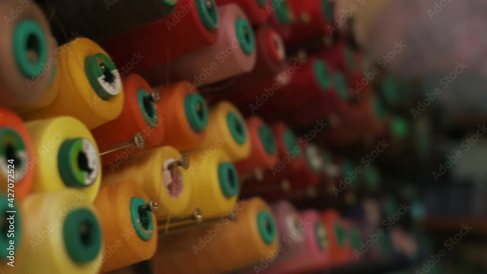 Spools of colored thread on a vertical stand. Spools of colored thread on a vertical stand.