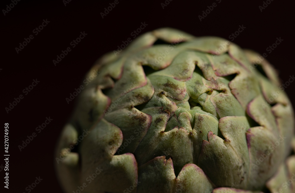 Fototapeta premium Close-up of an artichoke, against a dark background
