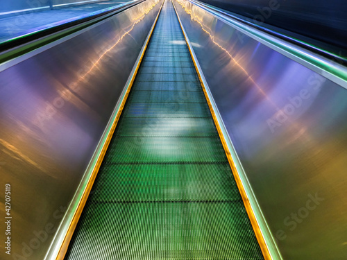 Long empty illuminated escalator people mover