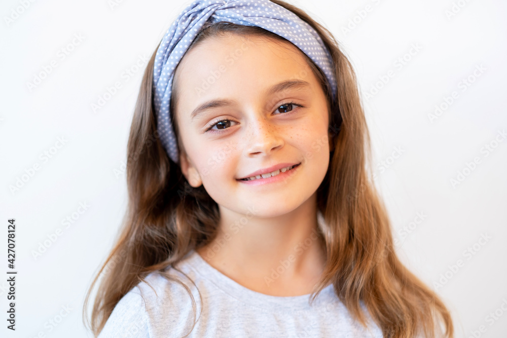 Kid portrait. Happy childhood. Positive lifestyle. Satisfied friendly proud sweet smiling brunette little girl face with freckles isolated on neutral background.
