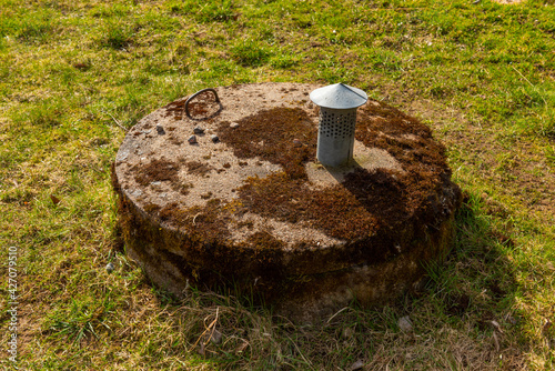 Mossy concrete lid on a well.