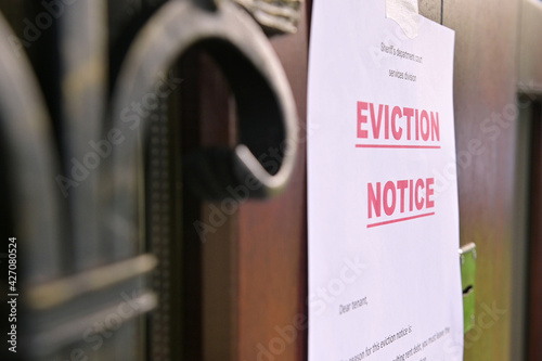 the notice of eviction of tenants hangs on the door of the house, front view photo