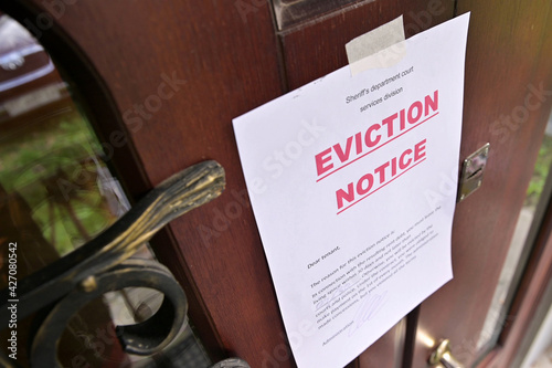 the notice of eviction of tenants hangs on the door of the house, front view photo