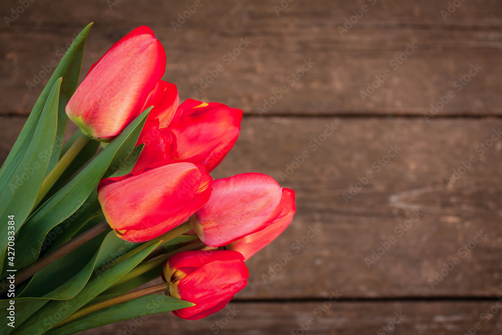 bouquet of red tulips on an rustic wooden table bouquet of red tulips on an rustic wooden table